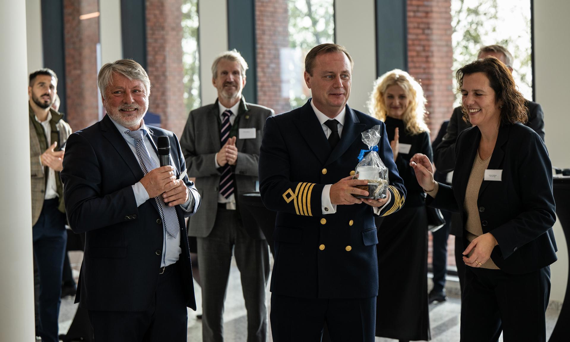 Theo Milliau and Evelyne Duthieuw from PSA Zeebrugge hands over a gift to captain Tobias Åkerblom