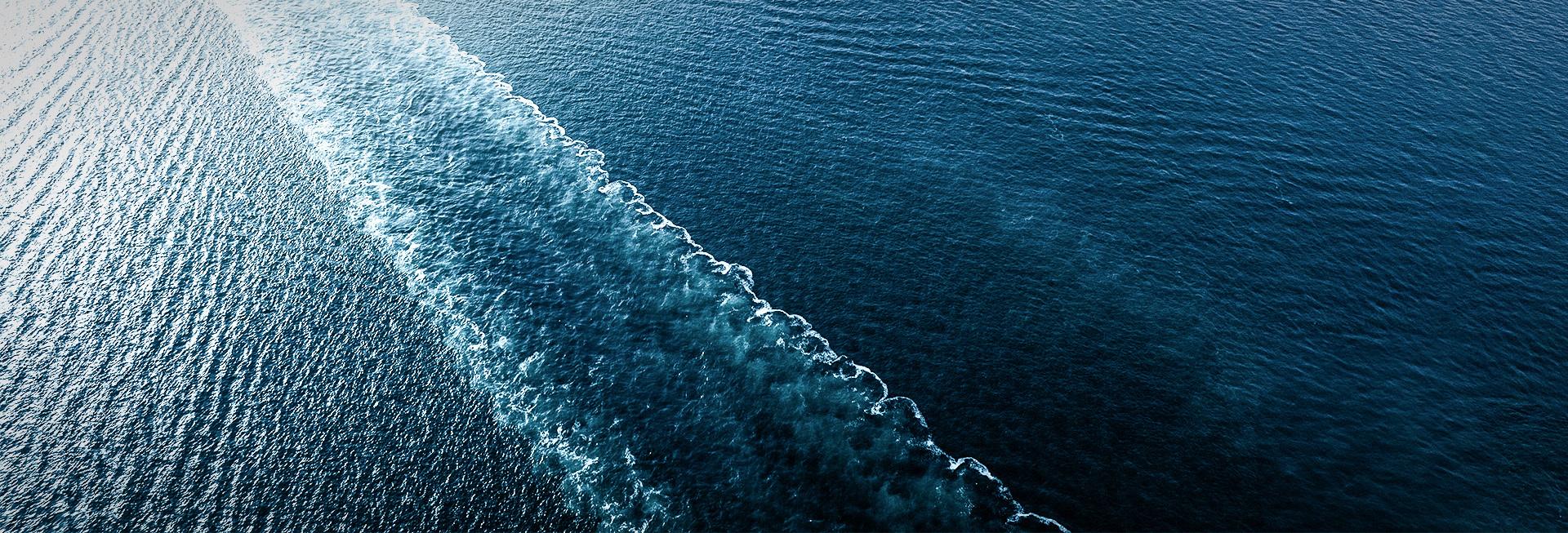 A sea with the wake of a passing ship in the water.